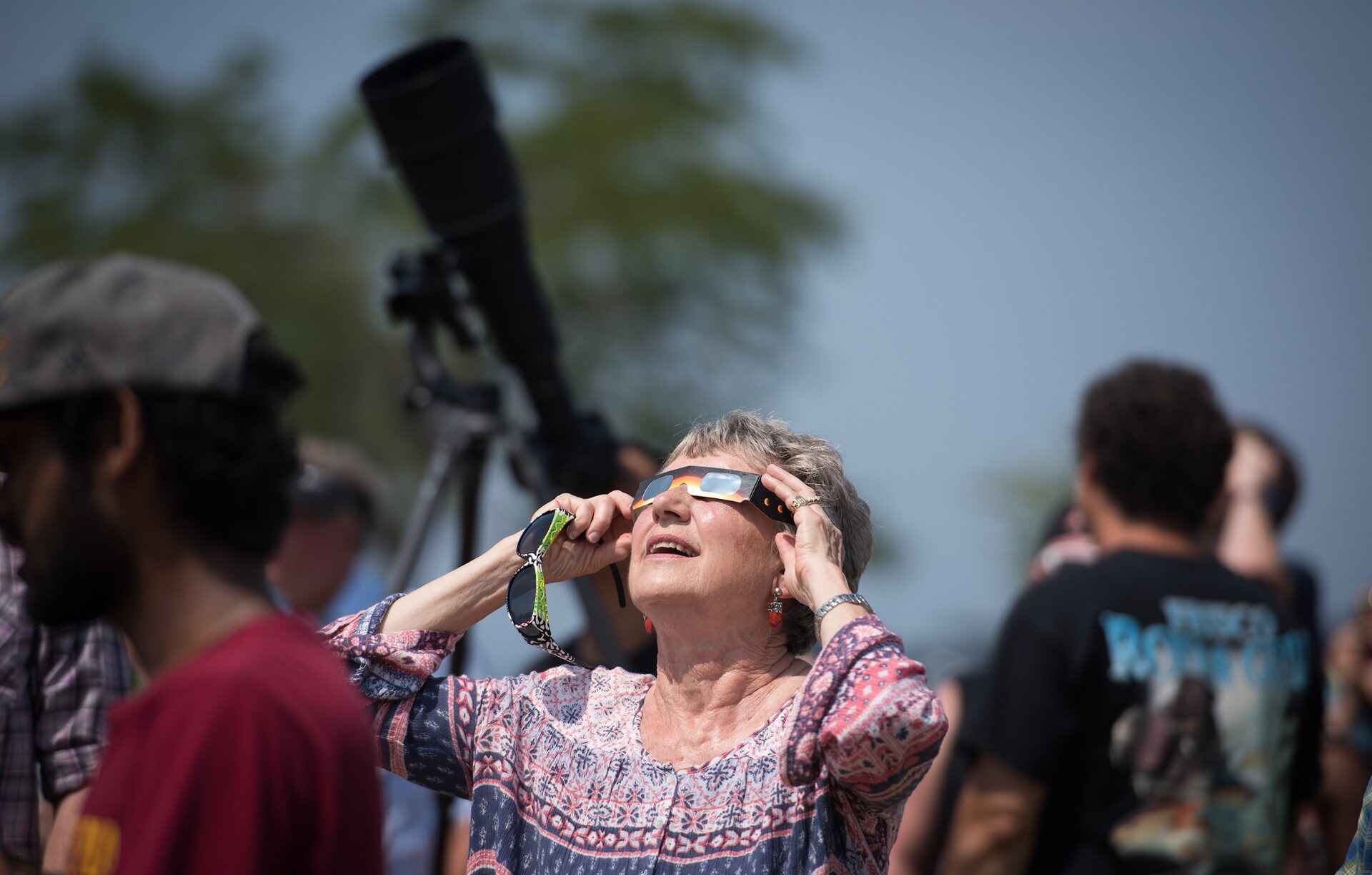 A woman looking at the eclipse using glasses