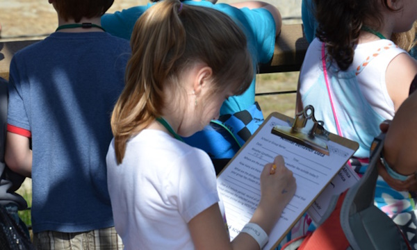 A little girl filling out a form 