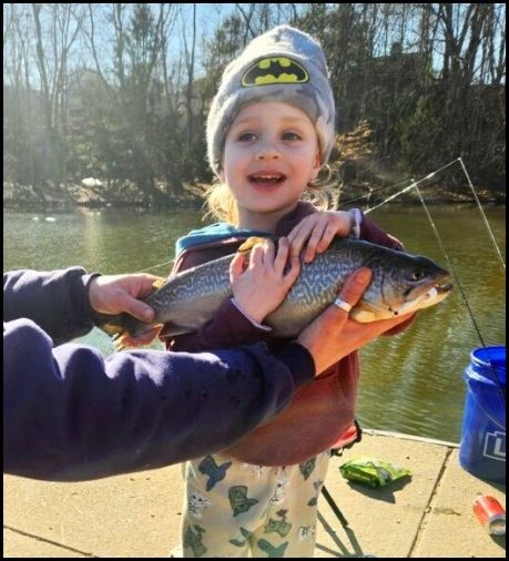 Child smiling and holding a fish