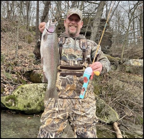 Person holding a fish and fishing rod