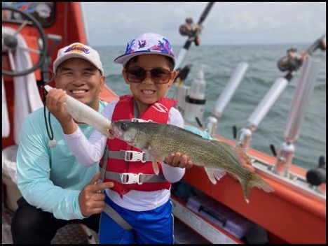 Boy smiling and holding a fish