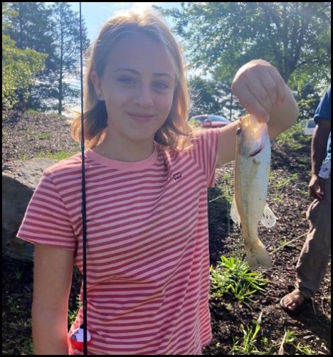 Child smiling and holding a fish