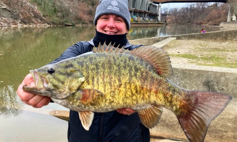 Person smiling and holding a fish