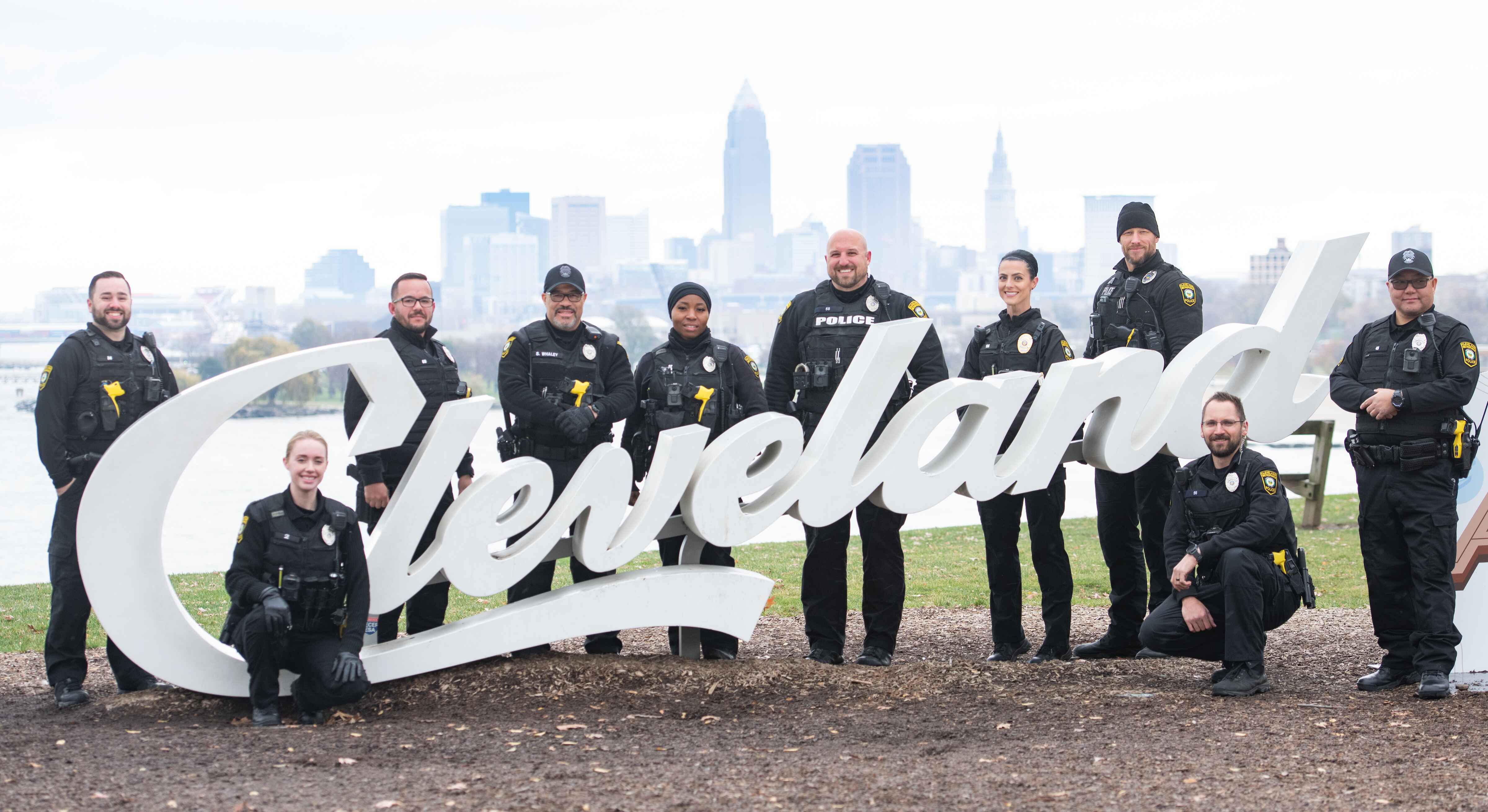 A group of police officers posing with a cleveland sign