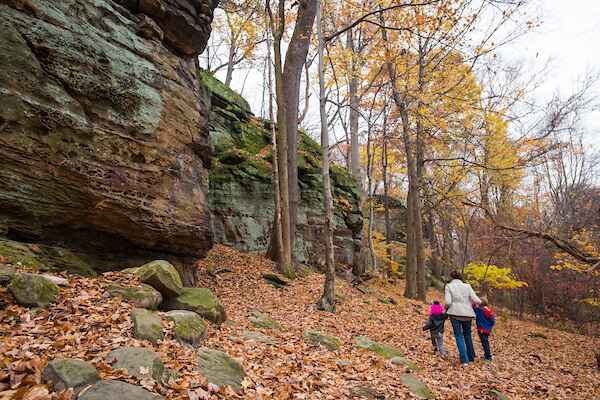 People walking among rock ledges in the forest